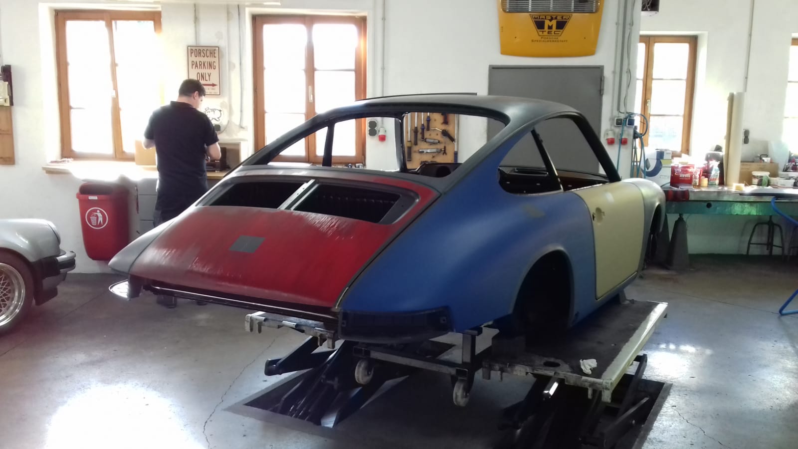 Heckansicht des FamosNine Porsche 912 in der Werkstatt mit Lackierer